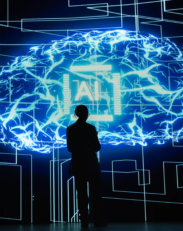 AI & Machine Learning: person facing a glowing AI neural network visualization