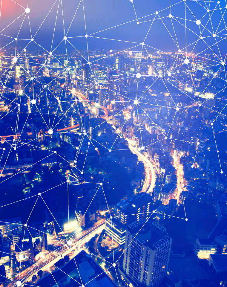 IoT & Edge Solutions: city lights at night connected by a digital network overlay