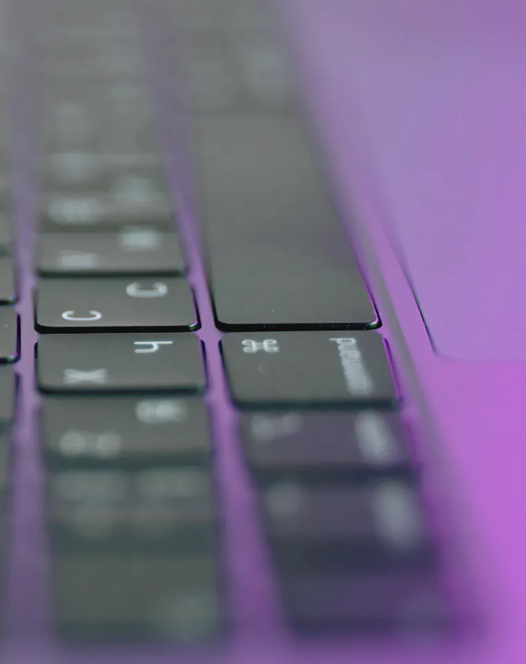 Content Generation & Marketing: close-up of a laptop keyboard in purple light