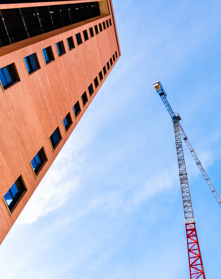 Process Assessment & Strategy Design: brick building and construction crane against the sky