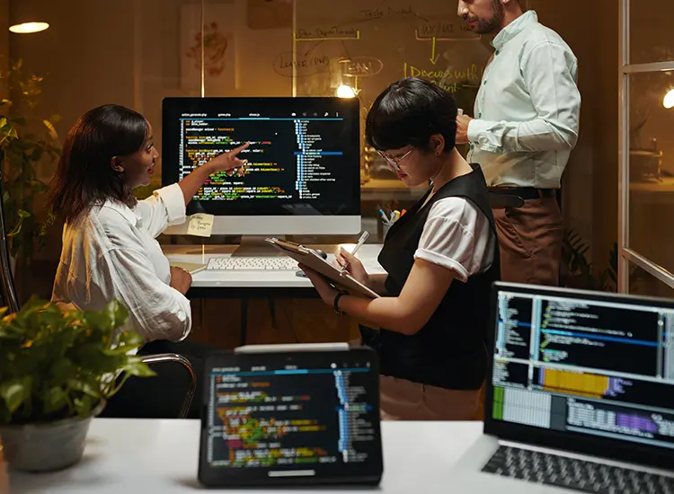 Is .NET Useful for Web Development?: development team collaborating around screens of code